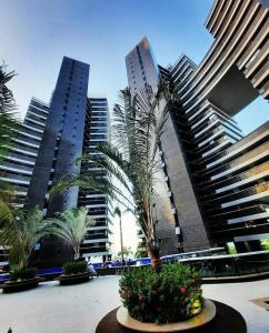 un grupo de edificios altos con palmeras en un patio en Apartamento Beira Mar by WL Temporada, en Fortaleza