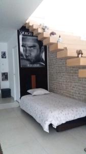 ein Bett in einem Zimmer mit einem Poster eines Mannes in der Unterkunft Chambre chez l'habitant LGBT près de la plage naturiste de Granville in Bréville-sur-Mer + 9 Fotos