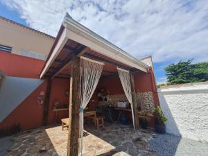 a patio with awning and a table in front of a building at EcoPousada Perequê - Pontal do Sul in Pontal do Paraná +8 photos