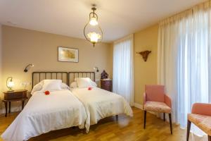 - une chambre dotée d'un lit avec des draps blancs et des fleurs rouges dans l'établissement Hotel Casa da Galbana, à Friol