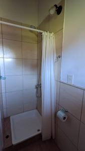 baño con ducha con cortina blanca en Lo De Pablo en Villa La Angostura