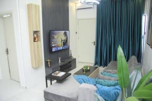 Televiisor ja/või meelelahutuskeskus majutusasutuses Cosy 2-Bedroom Apartment With Superfast Wifi and 24x7 Security and Electricity