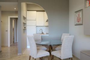 jadalnia ze szklanym stołem i krzesłami w obiekcie Contempora Apartments - Elvezia 8 - E51 w Mediolanie +7 zdjęć
