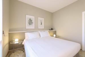 sypialnia z białym łóżkiem i 2 bocznymi stolikami w obiekcie Contempora Apartments - Elvezia 8 - E51 w Mediolanie