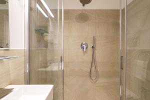 prysznic ze szklanymi drzwiami w łazience w obiekcie Contempora Apartments - Elvezia 8 - E51 w Mediolanie