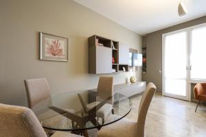 jadalnia ze szklanym stołem i krzesłami w obiekcie Contempora Apartments - Elvezia 8 - E51 w Mediolanie