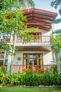 uma casa com varanda e árvores em frente em Lagoon gate Tangalle Resort em Tangalle