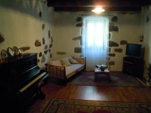 a living room with a couch and a piano at Casa Castori in Macomer