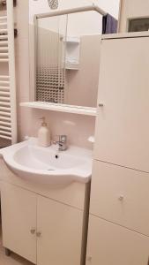 a white bathroom with a sink and a mirror at Casa Clau in Arad