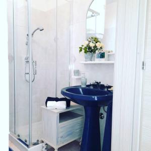uma casa de banho com um lavatório azul e um chuveiro em A casa di Nonna IUN Q2951 em Fluminimaggiore