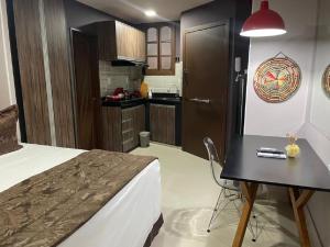 a bedroom with a bed and a table and a kitchen at Studio Bangalô Belém Hospedagem in Belém +171 photos