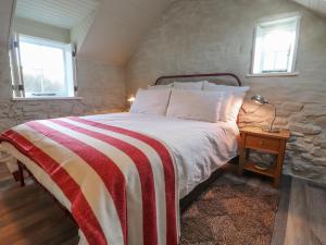 a bedroom with a large bed with a stone wall at Dolwylan Barn in Llandysul