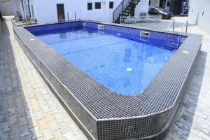 uma piscina com água azul num edifício em Cosy 2-Bedroom Apartment With Superfast Wifi and 24x7 Security and Electricity em Lekki