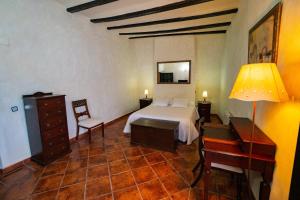um quarto com uma cama, uma secretária e um candeeiro em Casa Rural Moliner em Las Cuevas de Cañart