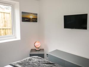 a bedroom with a bed and a flat screen tv at Sunnydene in Paignton