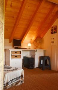 La ThuileChalet écologique à La Thuile avec vue sur montagne的一间卧室配有两张床和一张书桌及电视