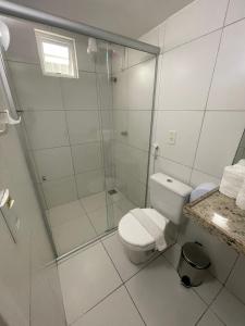 uma casa de banho com um WC e uma cabina de duche em vidro. em Hotel Rotorua inn Fortaleza - Beira Mar em Fortaleza