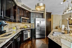 a kitchen with stainless steel appliances and wooden cabinets at Luxury & Highly furnished upscale w Patio & Garage in Plano