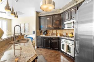 a kitchen with wooden cabinets and a stainless steel refrigerator at Luxury & Highly furnished upscale w Patio & Garage in Plano