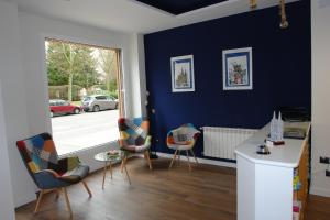 een woonkamer met blauwe muren en een tafel en stoelen bij Hostel Trovadores in Burgos