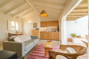 a living room with a couch and a kitchen at Casinha da Cabra, Casas do Poente, Rogil, Aljezur in Aljezur