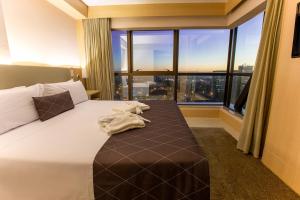 a hotel room with a bed with a large window at Cullinan Hplus Premium in Brasilia