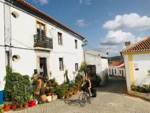 a person riding a bike down a street at Casinha da Cabra, Casas do Poente, Rogil, Aljezur in Aljezur