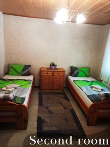 2 camas individuales en una habitación con mesita de noche en Gasthaus Katrin en Königslutter am Elm