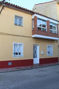 uma casa amarela com janelas brancas e uma rua em Casa Victor em Benissanet
