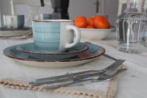 uma mesa com uma chávena de café e pratos e utensílios em Casa Victor em Benissanet