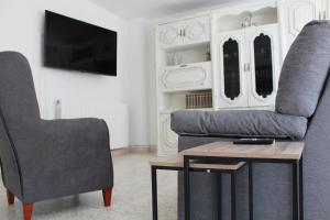 uma sala de estar com um sofá, uma cadeira e uma mesa em Casa Victor em Benissanet
