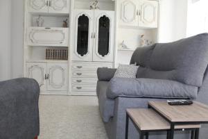 a living room with a gray couch and a table at Casa Victor in Benissanet