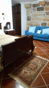 a living room with a bed and a couch and a rug at Casa Do Seminario in Gralhas +33 photos