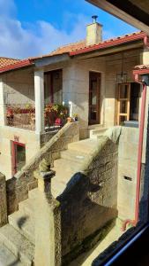 a stone house with a staircase in front of it at Casa Do Seminario in Gralhas