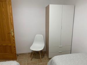 1 dormitorio con una silla blanca junto a un armario en Casa picena, en Picena