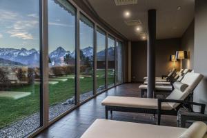 a waiting room with windows and chairs and mountains at Landhotel Stockerwirt in Vorderstoder