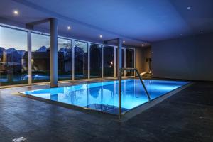 a large swimming pool in a house with windows at Landhotel Stockerwirt in Vorderstoder