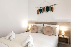 um quarto com uma cama branca com almofadas em Nazaré Top Wave na Nazaré