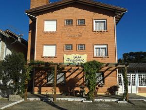 
a building with a sign on the front of it at Hotel Pequenino in Canela
