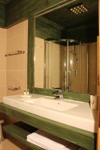 uma casa de banho com um lavatório branco e um espelho. em Jägerhaus Agriturismo em Cortina dʼAmpezzo