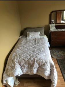 a bed with a white comforter in a bedroom at Peaceful in Myshall