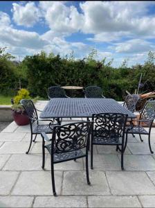 - une table et des chaises noires sur la terrasse dans l'établissement Peaceful, à Myshall