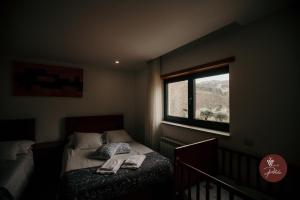 ein kleines Schlafzimmer mit einem Bett und einem Fenster in der Unterkunft Casa da Adega - Quinta da Portela in Terras de Bouro + 35 Fotos