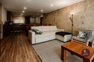 ein Wohnzimmer mit einer weißen Couch und einem Tisch in der Unterkunft Casa da Adega - Quinta da Portela in Terras de Bouro