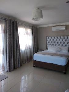a bedroom with a large bed and windows at La Saville BnB in Scottburgh