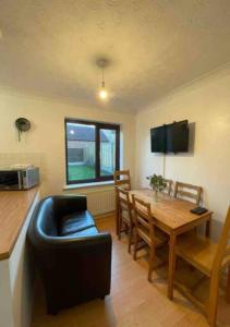 a kitchen and dining room with a table and a couch at 6 Bedroom House For Corporate Stays in Corby Suitable for Nightshift Workers in Great Oakley