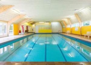 a large indoor swimming pool with blue water at La cabane, Durbuy in Durbuy