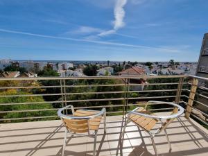 two chairs on a balcony with a view of a city at Apartamento em Tavira by Homekeys in Tavira
