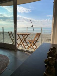 Cette chambre dispose d'une table et offre une vue sur la plage. dans l'établissement Studio Ribella West 2, à La Panne