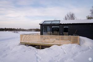 a cabin in the snow with snow around it at Flatmoen Natur Lodge in Alta